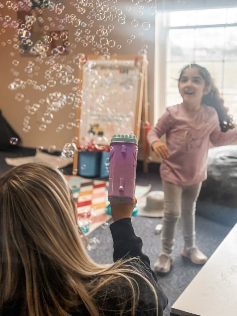 Therapist and child playing with bubbles